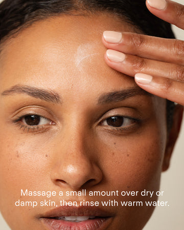 A person massages Ultra Calming Cleanser 300mL onto their forehead. Text on the image: Massage a small amount over dry or damp skin, then rinse with warm water—ideal for sensitive skin.