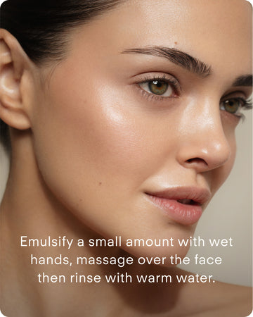 Close-up of a woman’s face with radiant skin. Instructional text at the bottom: Emulsify a small amount of B² Hydrating Balancing Gel Facial Cleanser with wet hands, massage onto face, then rinse with warm water.