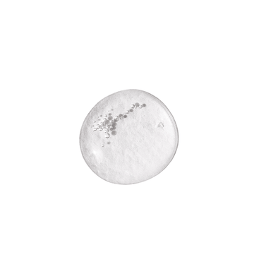 A clear, round droplet of Even Skintone Smoothing Serum Concentrate with suspended bubbles, set against a plain white background—an ideal gentle liquid exfoliator for addressing uneven skin tone.