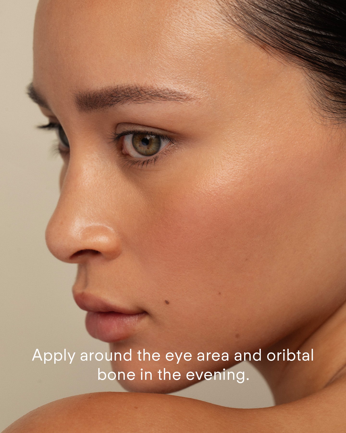 A close-up of a woman's face in profile with smooth skin and natural makeup. White text at the bottom reads: Apply Ultra A Perfecting Eye Cream around the eye area and orbital bone in the evening to target fine lines.