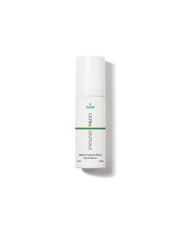 A white bottle of Z Clear Shikimic Hydroxy-Biome Facial Serum stands upright on a plain white background, featuring minimal text and a green accent line on its label.