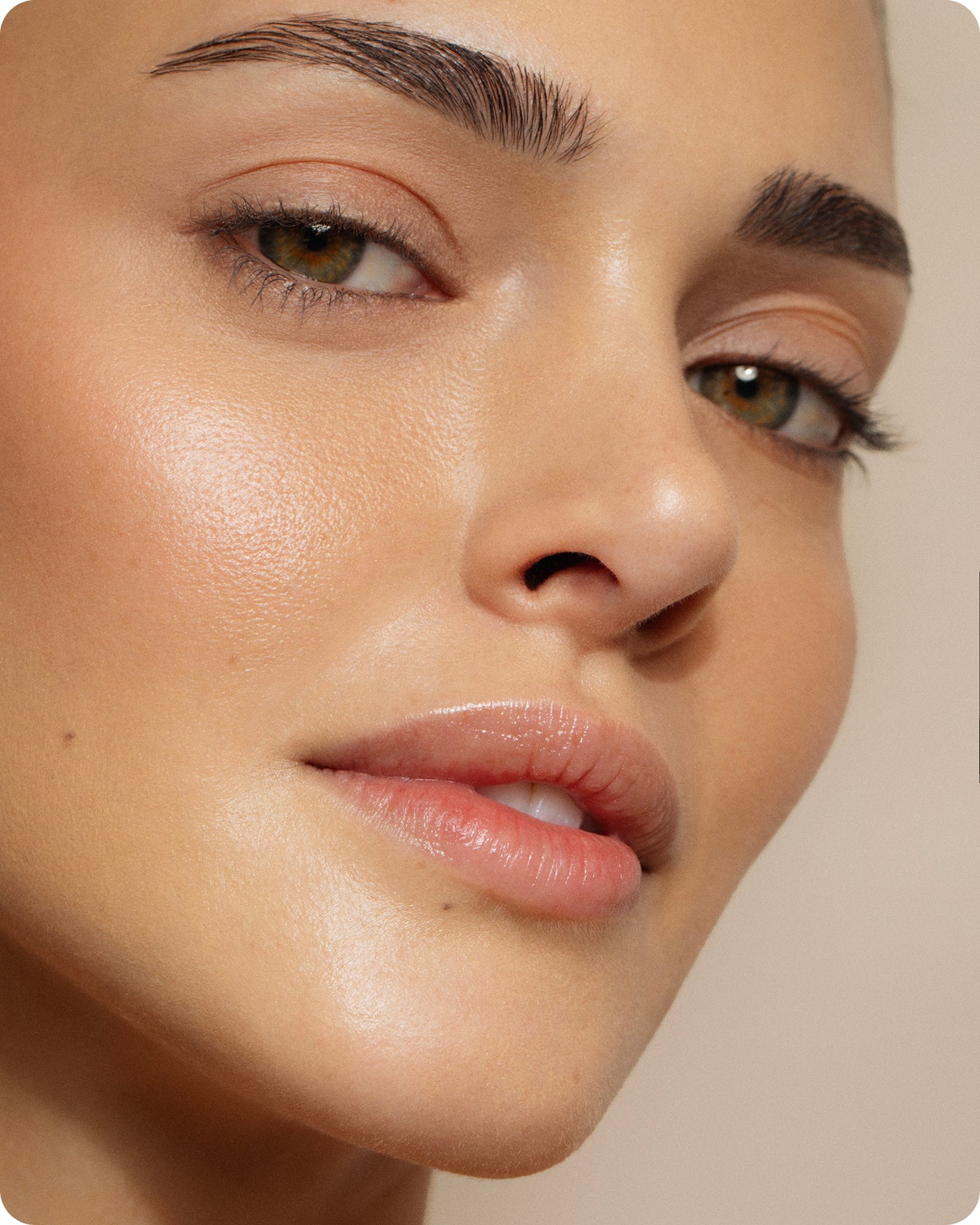 A close-up of a woman’s face with smooth, glowing skin, well-groomed brows, and subtle eye makeup. Her radiant, youthful complexion and reduced fine lines highlight the benefits of using the Ultra B² Hydrating Eye Mask.