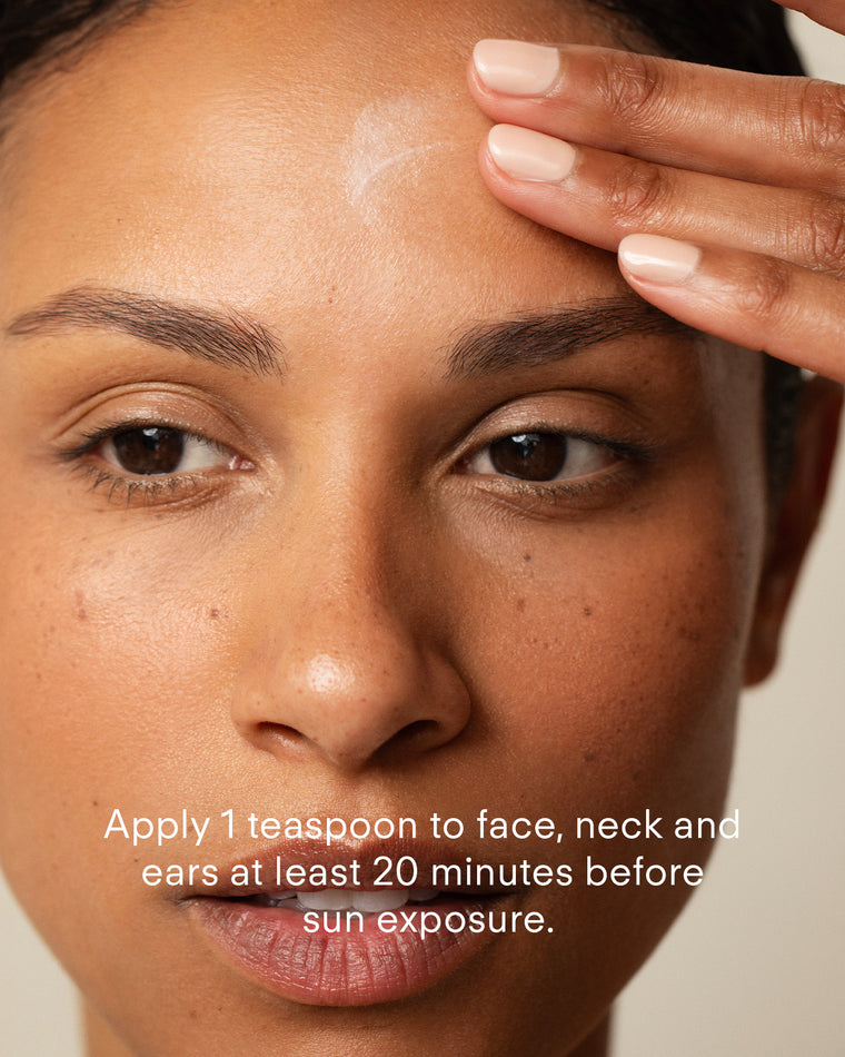 A person applies Ultra UV Protective Daily SPF50 Hydrating to their forehead with a fingertip. Text on the image reads: Apply 1 teaspoon to face, neck, and ears at least 20 minutes before sun exposure.