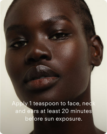 A close-up of a person with smooth, dark skin looking at the camera. Text: Apply 1 tsp of Ultra UV Protective Daily SPF30 Sheer Tint to face, neck, and ears at least 20 minutes before sun exposure.