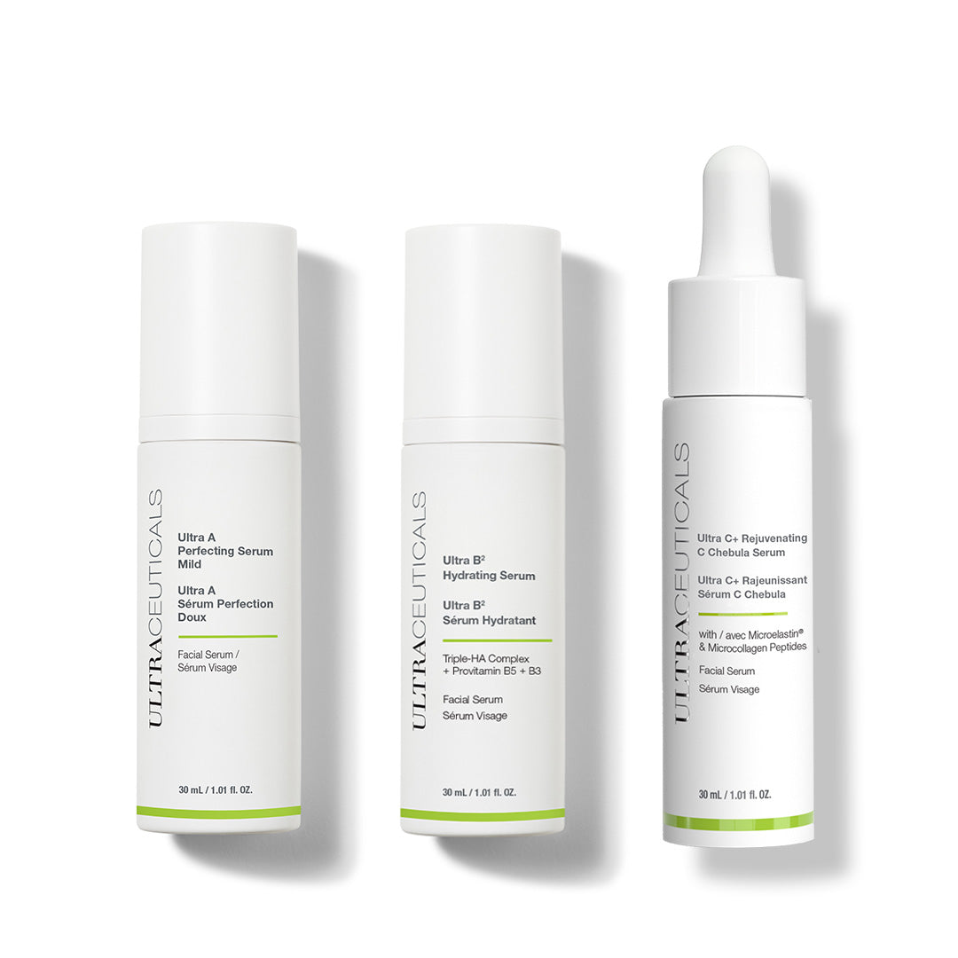 Three white bottles of The Complete ABC Renewal Set—Vitamin C, hydrating, and Vitamin A serums—stand upright on a white background, each with distinct labeling and unique dispenser tops: pump, spray, and dropper.