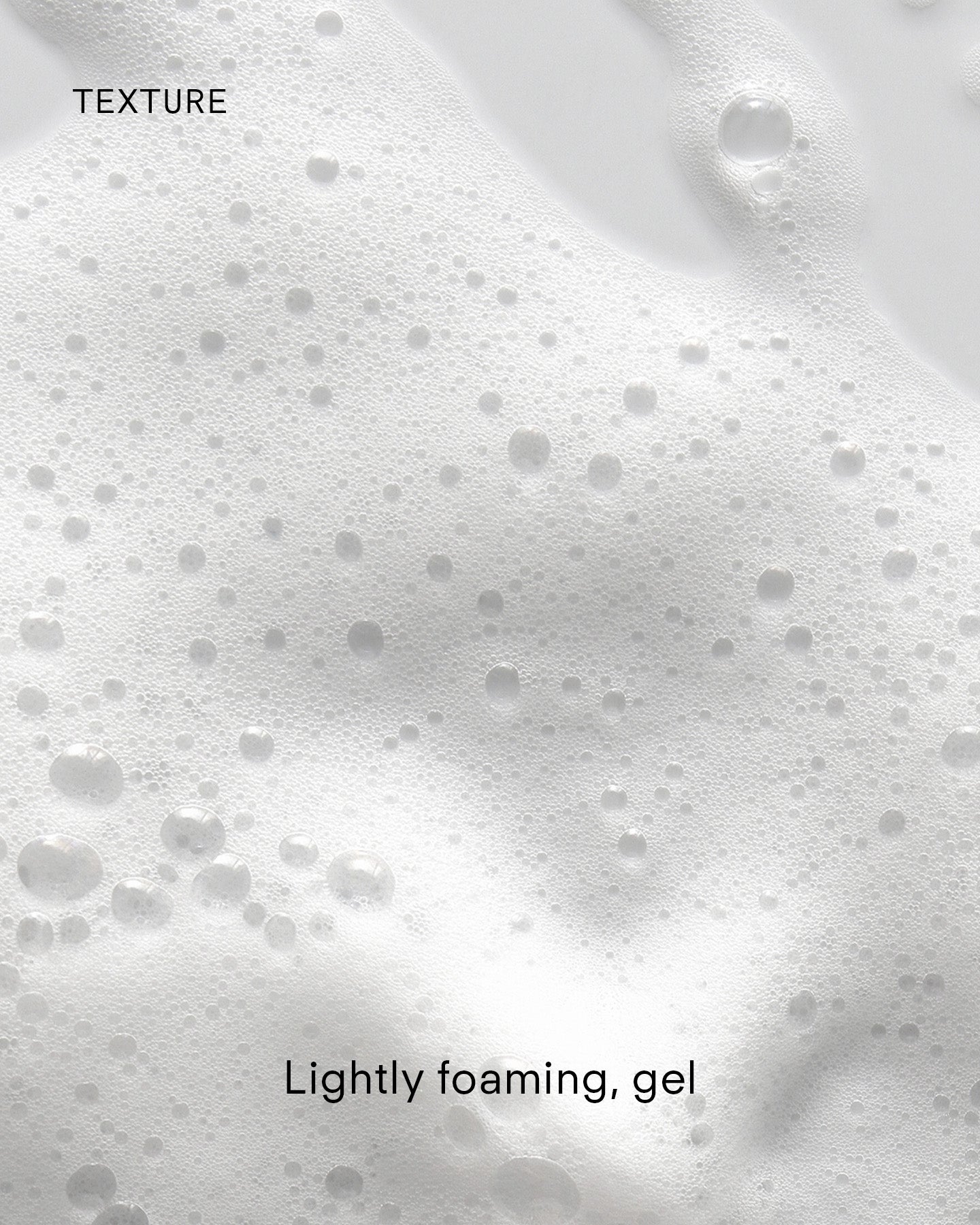 Close-up of Ultra Balancing Gel Cleanser's lightly foaming gel with small and large bubbles on a smooth, white surface, suggesting hydration. The image features the words “TEXTURE” and “Lightly foaming, gel.”.